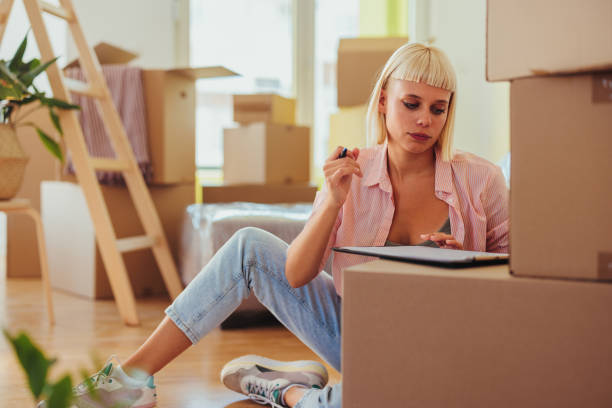 Woman writing list for moving stock photo