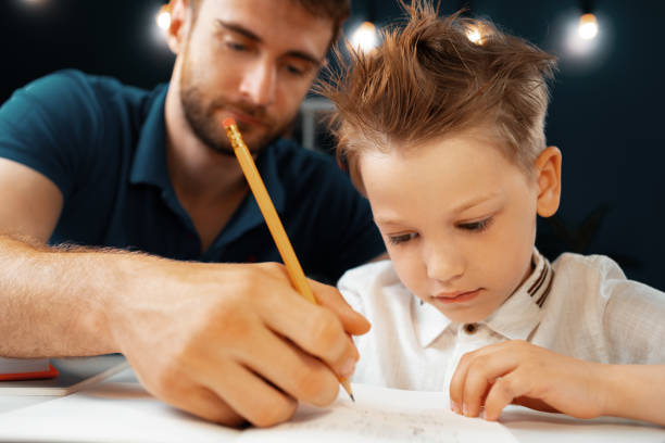 istock Father helping his little son with school homework 1421894469