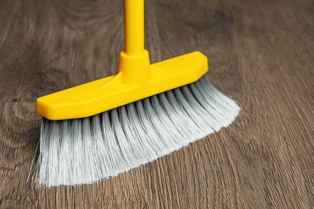 istock Sweeping wooden floor with plastic broom, closeup 1421903549