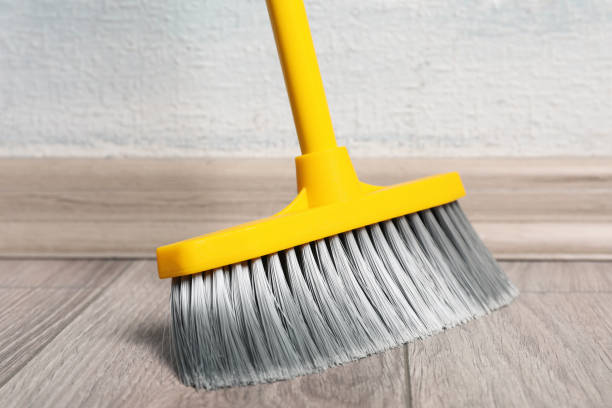 istock Sweeping wooden floor with plastic broom, closeup 1421903576