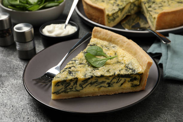 istock Piece of delicious spinach pie served on grey table, closeup 1421904356