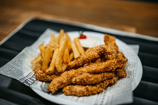 Sesame chicken and French fries serving in a pub.