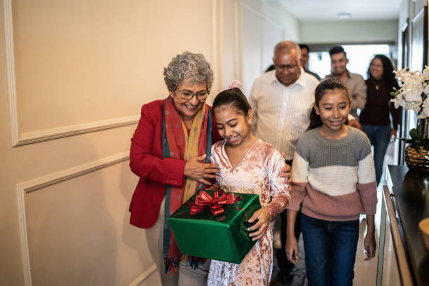 istock Child holding christmas present while family enters home 1421911097
