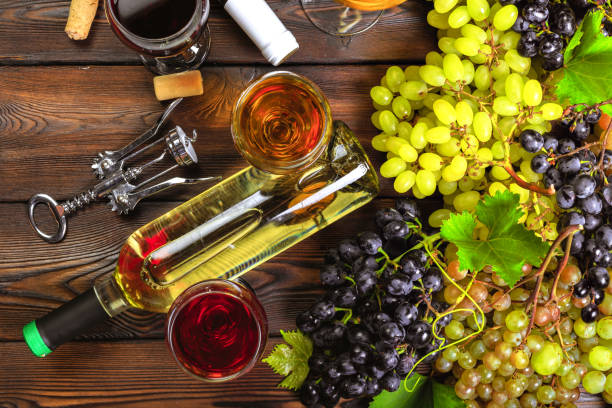 istock wine with branches of white grapes. On a wooden table. 1421911160