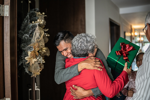 Son greeting mother on christmas at home