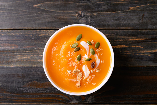 Butternut squash pumpkin soup in bowl on wooden background, Homemade food in autumn season