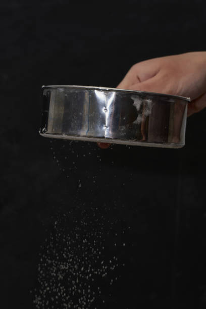 istock a man sifts flour through a sieve on a black background 1421914362