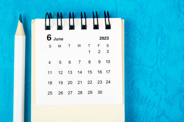 The June 2023 Monthly desk calendar for 2023 with pencil on blue background. stock photo