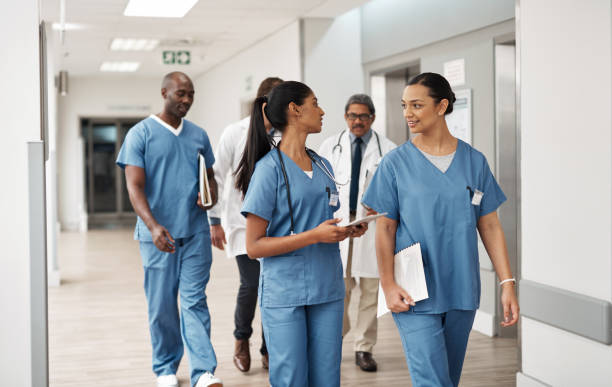 Doctor, nurse and walking hospital team after success surgery, medicine meeting or clinic insurance planning. Diversity workers, smile and happy medical healthcare teamwork on treatment collaboration médico, enfermera y equipo del hospital que camina después de la cirugía exitosa, la reunión de medicina o la planificación del seguro de la clínica. trabajadores de la diversidad, sonrisa y feliz trabajo en equipo de atención médica en colaboraci�