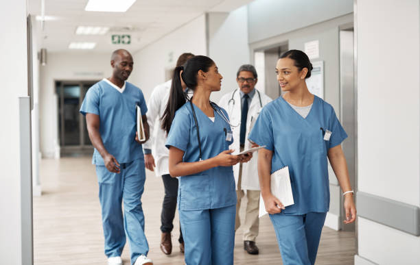 doctor, nurse and walking hospital team after success surgery, medicine meeting or clinic insurance planning. diversity workers, smile and happy medical healthcare teamwork on treatment collaboration - medical occupation imagens e fotografias de stock