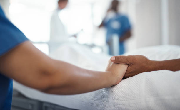 Doctor, holding hands of patient and support after cancer diagnosis at a hospital bed. Health, healthcare and hope with medical consultant, nurse or loved one comforting sick person in a clinic room Doctor, holding hands of patient and support after cancer diagnosis at a hospital bed. Health, healthcare and hope with medical consultant, nurse or loved one comforting sick person in a clinic room touch sensitive stock pictures, royalty-free photos & images