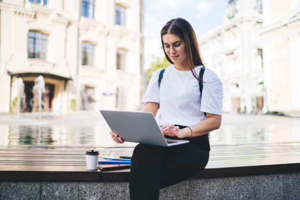 istock Casual dressed hipster girl in eyewear using modern laptop device for installing banking application and make online travel booking, Caucasian digital nomad update web information in own blog 1421919921