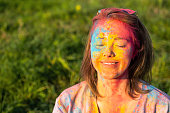 Woman covered holi powder in park. Holi colours festival.