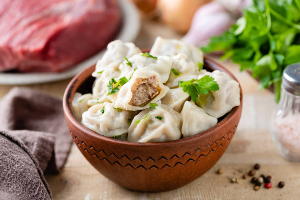 Meat stuffed dumplings Pelmeni Meat stuffed dumplings Pelmeni or Tortellini in a bowl, closeup view russian pelmeni stock pictures, royalty-free photos & images