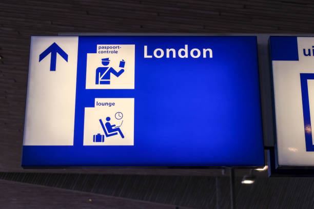 Direction sign on platform to customs gate for train to London from Rotterdam Central station in the Netherlands