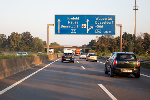 Neuss, Germany - September 06, 2021: Traffic on german Autobahn A 57 nearby Dreieck Neuss-Sued. Bundesautobahn 57 (abbreviated as BAB 57 or A 57) is a German Autobahn that begins at the Dutch-German border near Goch and ends in Cologne. Some road users in the background.