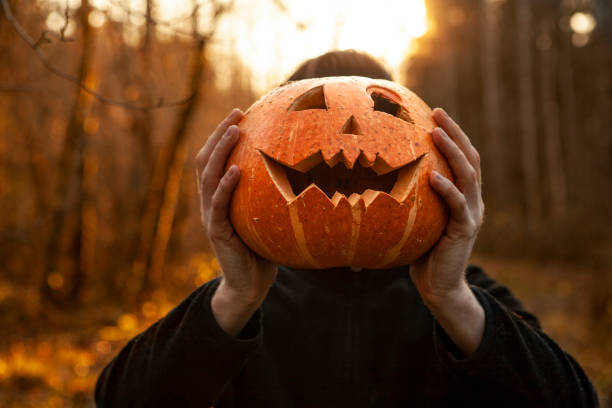 A young man and Jack O' Lantern stock photo
