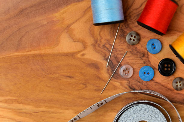 istock Sewing accessories and fabric on a wood background. 1421934111