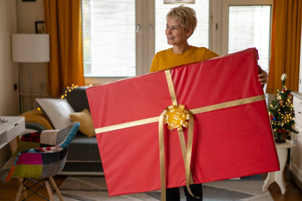 istock Woman is holding a huge Christmas gift 1421937444