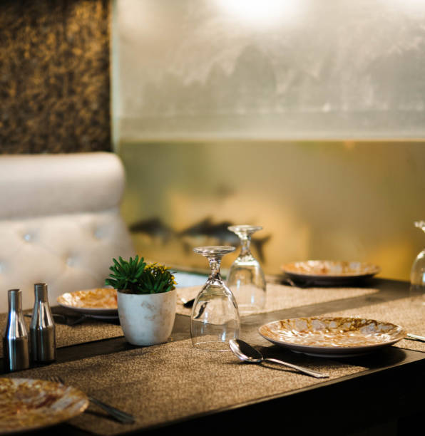 Restaurant table with cluttered plates & Flipped wine glasses