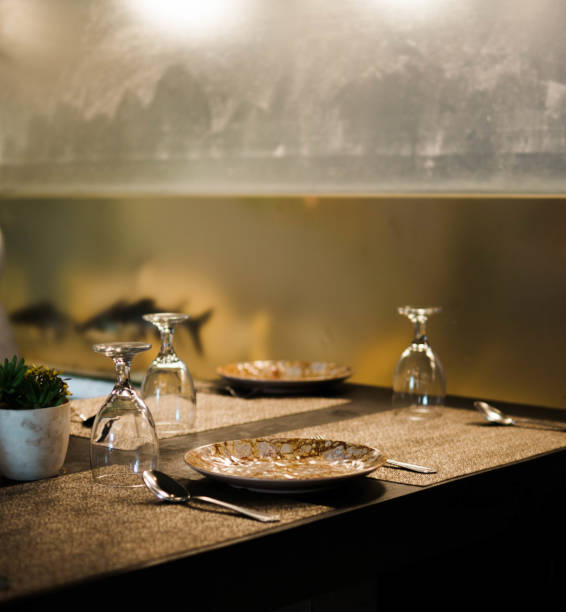 istock Restaurant table with cluttered plates & Flipped wine glasses 1421939167