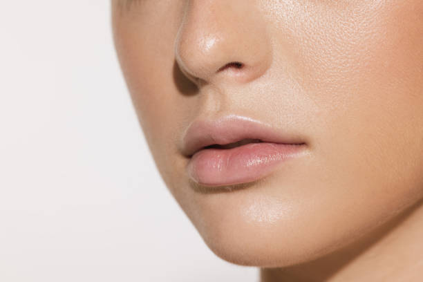 istock Closeup female lips, cheeks and nose isolated over white studio background. Concept of cosmetology, skincare, cosmetics, plastic surgery, ad 1421939412