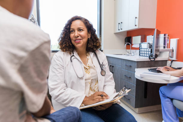 une femme médecin empathique écoute un garçon méconnaissable - primary care photos et images de collection