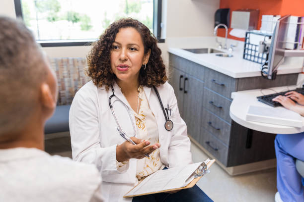 istock Female pediatrician talks to unrecognizable elementary age boy 1421939485