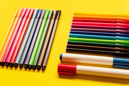 Coloured pencils arranged on pink background