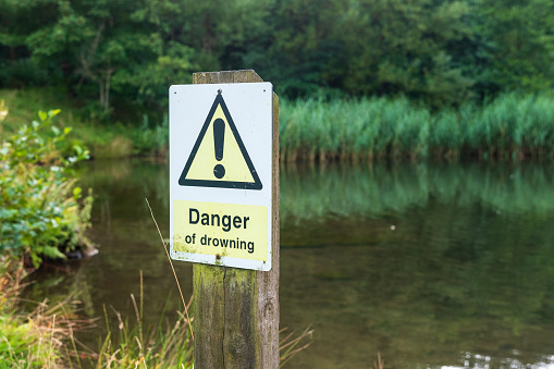 Sign warning of the danger of drowning on the edge of a lake in Wales