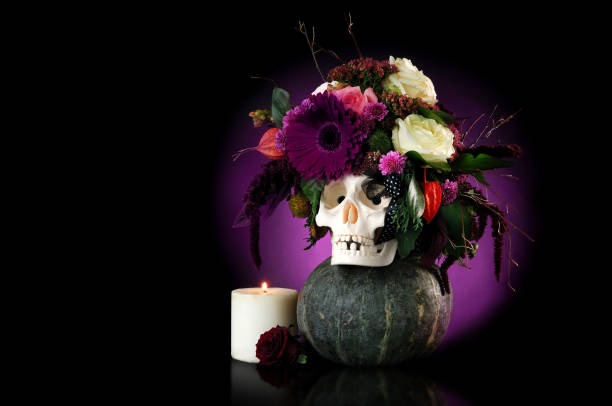 istock Skull decorated with flowers and a burning candle on dark background 1421948093