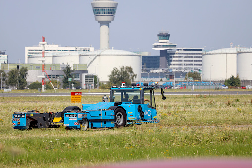 Aircraft tractor of the klm on taxi strip next to aalsmeer runway on Amsterdam Schiphol Airport in the Netherlands