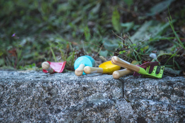 istock Set of gardening tools displayed side by side, outdoors on a rock and vegetation as a background. 1421953607