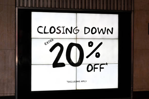 istock Closing down sale sign lit up in a shop window 1421954196