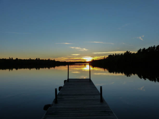 istock Sunset over pier on lake in fall 1421956038