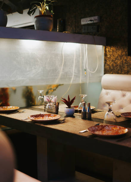 istock Restaurant table with unorganized plates & Flipped wine glasses 1421957430