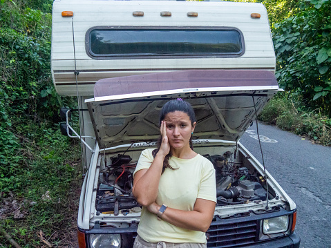 She stands in front of the RV with an anxious face looking at the camera.