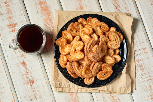 Puff pastry cookies palmier or elephant ears, caramelized and crunchy pastry with coffee.