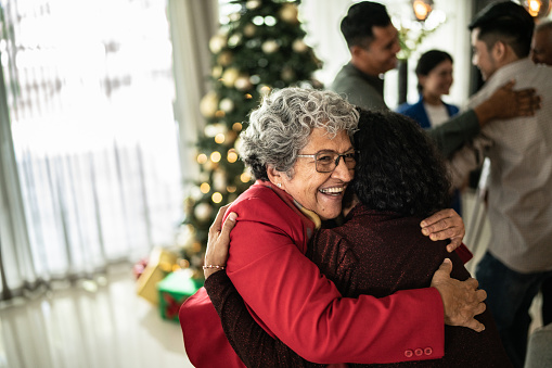 Senior woman hugging her daughter on christmas at home