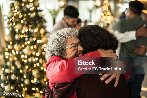 istock Senior woman hugging her daughter on christmas at home 1421959902