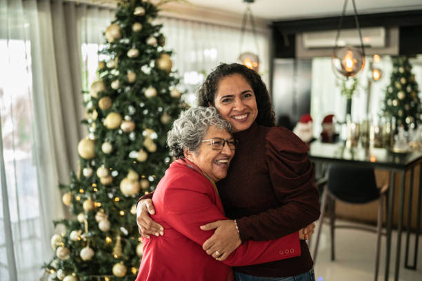 Portrait of mother and daughter hugging on christmas at home stock photo
