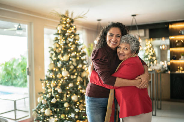 Portrait of mother and daughter hugging on christmas time at home stock photo