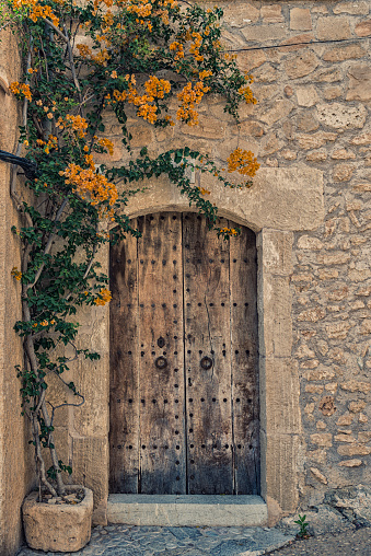 Old wooden door in a stone wall. Old town in Spain, Europe.