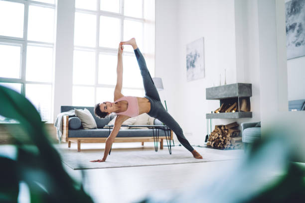 istock Optimistic young lady bending during yoga workout in modern room 1421961332