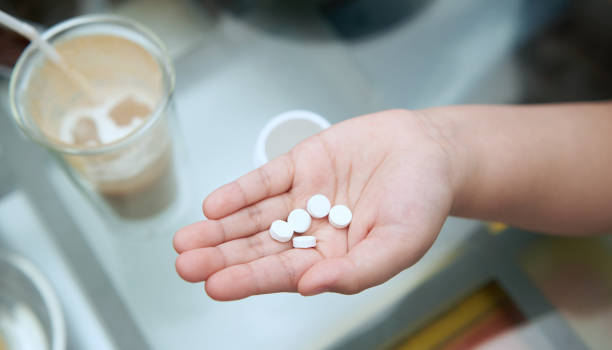 istock child hand hold pills on palm side on blur drink background 1421964371