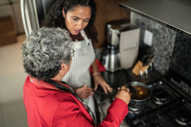 istock Mother and daughter talking while cooking in the kitchen at home 1421965587