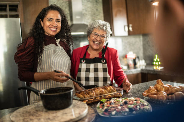istock Mother and daughter talking while preparing food at kitchen counter at home 1421966241