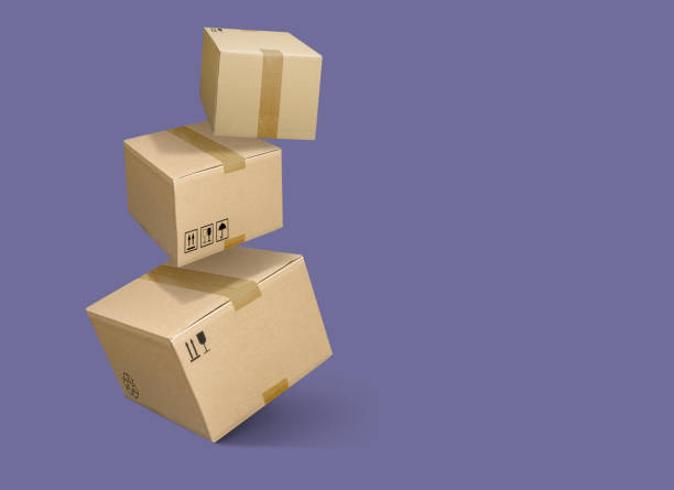 Cardboard parcel boxes falling on violet purple background Closed and taped cardboard parcel boxes falling on violet background cardboard box stock pictures, royalty-free photos & images