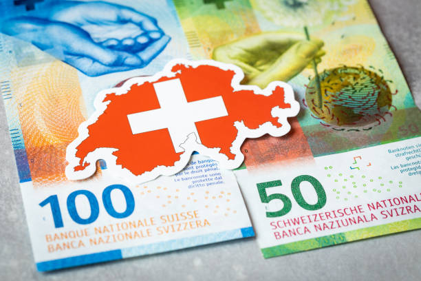 bandera suiza en el contexto de los francos suizos, concepto de seguridad monetaria - swiss currency fotografías e imágenes de stock