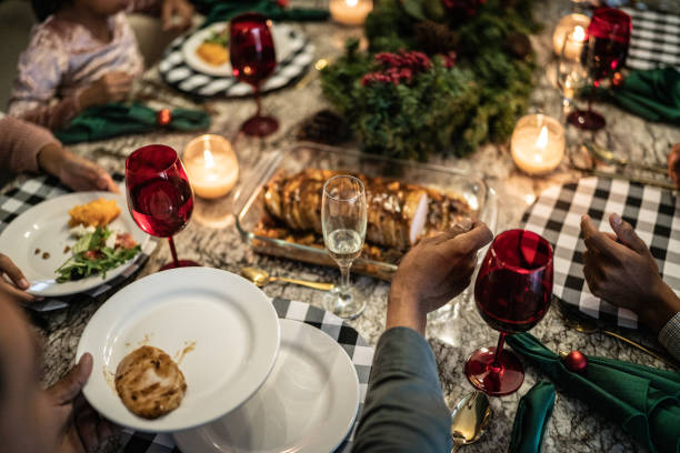 istock Man putting loin with fruit on plate in the dinner table on christmas at home 1421968068